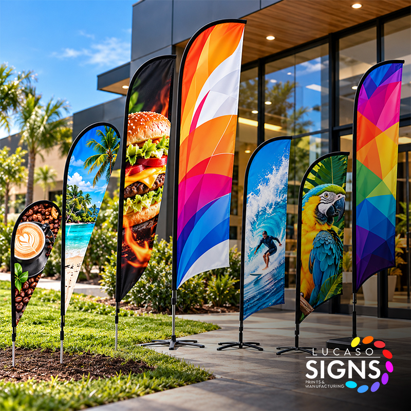Custom printed feather and teardrop advertising flags in various sizes, displayed outdoors with full-color promotional graphics and portable flag bases.